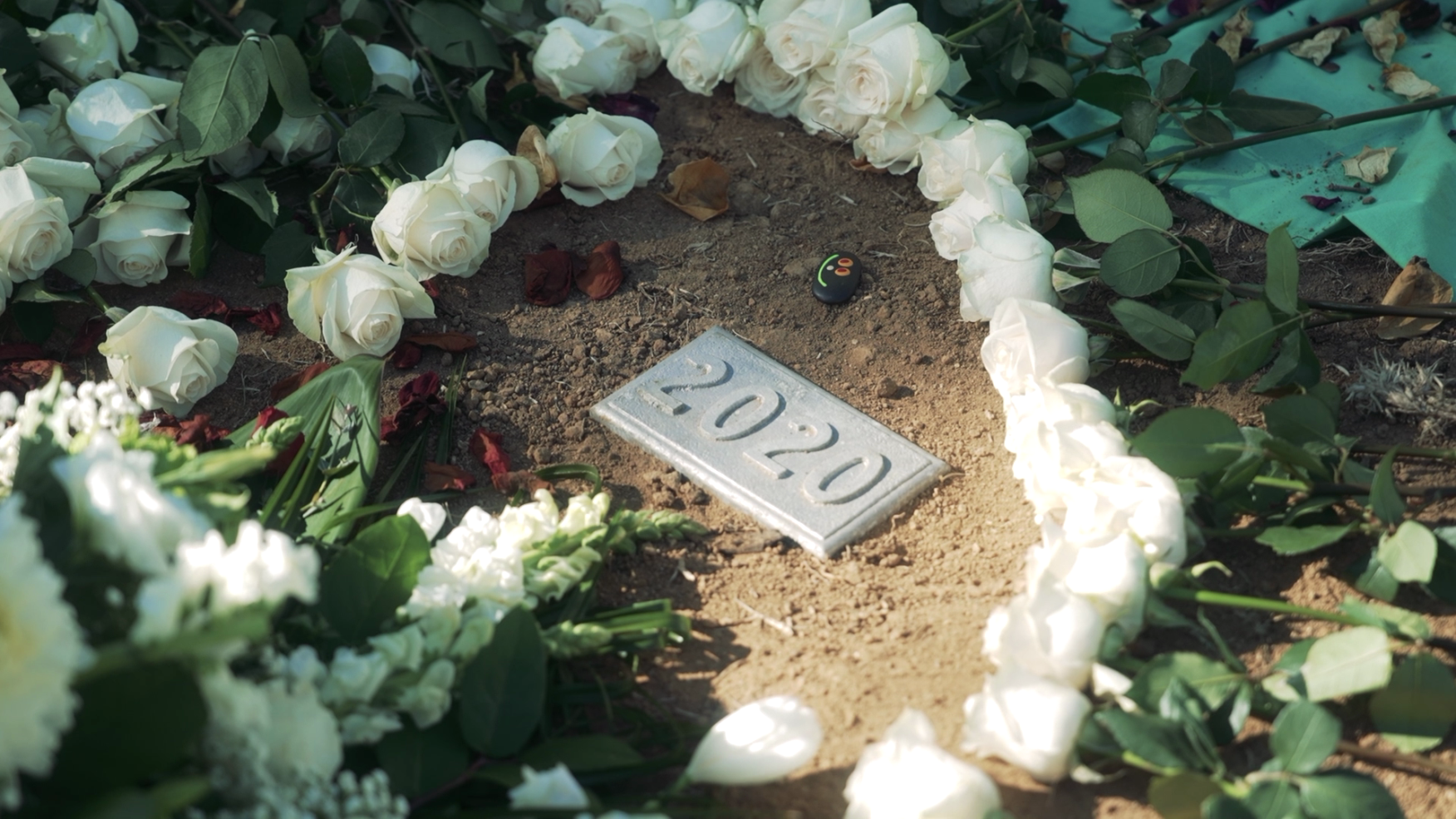 Photos of a grave marker with 2020 on it surrounded by flowers